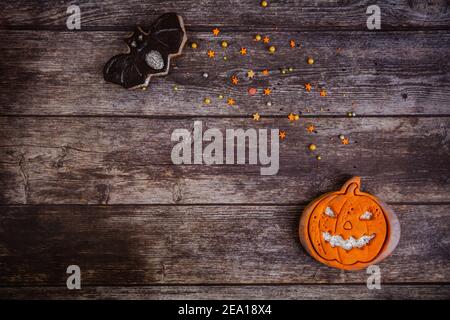 Handbemalter Lebkuchen gruselig Halloween alte Jack-o-Laterne Kürbis mit farbigen Streuseln auf Holzhintergrund. Draufsicht. Flach liegend. Speicherplatz kopieren Stockfoto