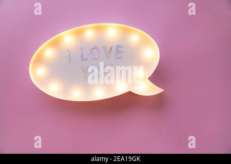Kreative Valentinstag romantische Komposition. Flach Lay Liebe Feiertag Feier Text I love you auf Leuchtkasten auf rosa Hintergrund mit Kopieplatz für desi Stockfoto