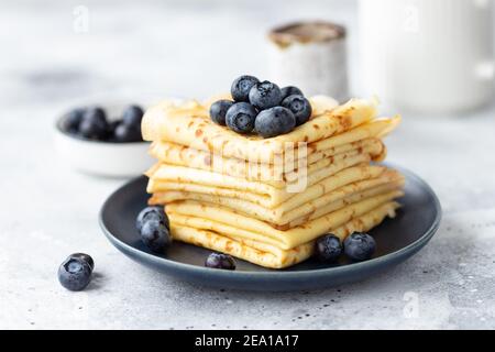 Frisch gebackene dünne Pfannkuchen, Crepes auf blauem Teller Stockfoto