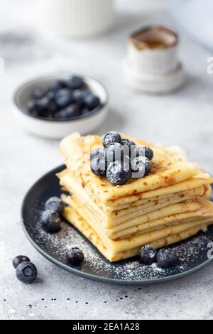 Crepes mit Blaubeeren auf grauem Hintergrund stapeln Stockfoto