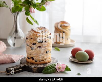 Osterkuchen Cruffin und bemalte Eier auf Fensterhintergrund Stockfoto