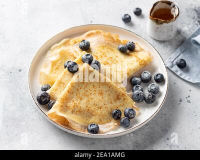 Dünne Pfannkuchen, Crepes mit Heidelbeeren auf weißem Teller Stockfoto