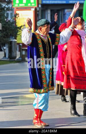 Zhangye, China-20. Oktober 2017: Am frühen Morgen-Gruppe von älteren Tänzern in Uiguren Kleidung gekleidet führen traditionelle Choreografien zum Klang der Stockfoto