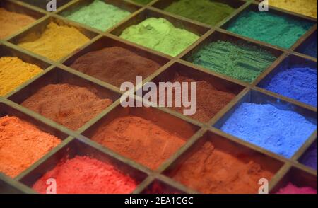 Künstlerische Farben Pulver in Holzkiste mit Fächern. Hintergrund mit farbenfroher Textur. Stockfoto