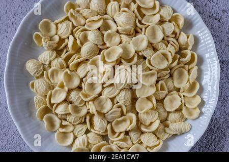 Orecchiette, typisch italienische frische Pasta in einem weißen Gericht. Stockfoto