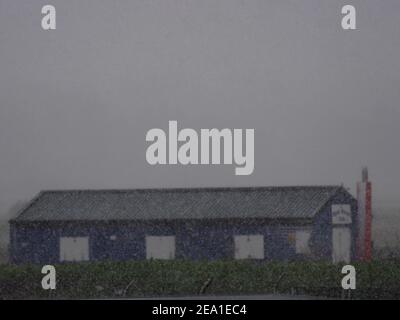 Sheerness, Kent, Großbritannien. 7th. Februar 2021. UK Wetter: Schneeregen und starke Winde in Sheerness, Kent heute Morgen als Storm Darcy beginnt zu schlagen. Bartons Point Cafe Gebäude im Sturm. Kredit: James Bell/Alamy Live Nachrichten Stockfoto