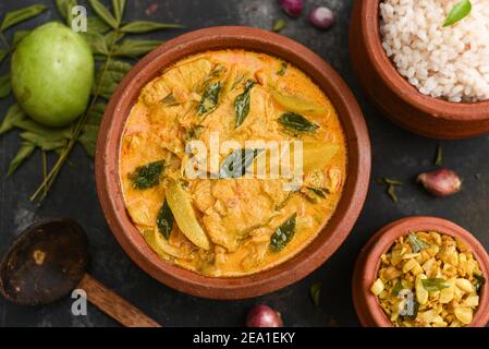 Draufsicht würziges scharfes Bengali Rohu oder King Fish Curry. Indisches Essen. Fischcurry mit roter Chili, Curryblatt. Asiatische Küche. Frau Hand nehmen würzigen Kerala, Stockfoto