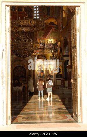 PODGORICA, MONTENEGRO - AUGUST 17: Ein Paar in der Auferstehungskathedrale in Podgorica blickt auf die Ikonen Jesu Christi. Aufgenommen 2014