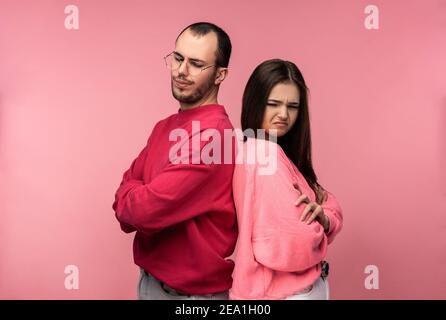 Foto von attraktiven Paar steht zurück zu Rücken und sieht ärmlich und verzweifelt, isoliert über rosa Hintergrund Stockfoto