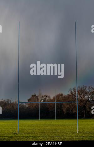 Rugby-Pfosten unter einem stürmischen Himmel mit einem Regenbogen in Der Himmel über uns Stockfoto