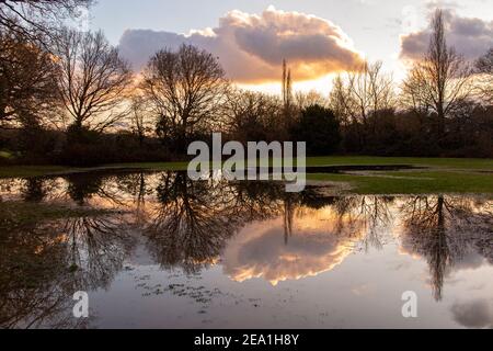 Ein wasserdichtes Feld in einem Winter Sonnenuntergang nach Wochen Starker Regen Stockfoto