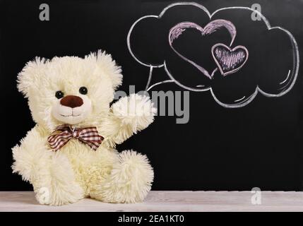 Teddybär in der Nähe der Tafel. Valentinstag Hintergrund. Kreide Herz. Stockfoto