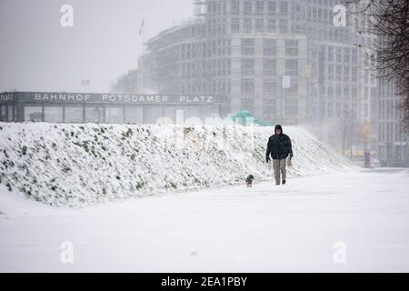 Berlin, Deutschland. Februar 2021, 07th. Deutschland, Berlin, 07. Februar 2021: Ein Mann mit seinem Hund ist bei Schneefall in Berlin Mitte zu sehen. Der Deutsche Wetterdienst warnt vor heftigem Schneefall mit Windwirbeleien bei Temperaturen, die deutlich unter dem Gefrierpunkt liegen. (Foto: Jan Scheunert/Sipa USA) Quelle: SIPA USA/Alamy Live News Stockfoto