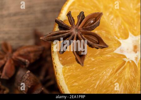 Eine halbe Orange und ein Sternanis auf einem Holztisch. Nahaufnahme, selektiver Fokus. Stockfoto