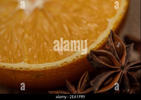 Eine halbe Orange und ein Sternanis auf einem Holztisch. Nahaufnahme, selektiver Fokus. Stockfoto