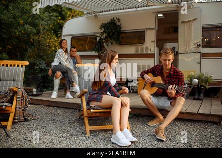 Freunde spielen auf Gitarre auf Picknick beim Camping Stockfoto