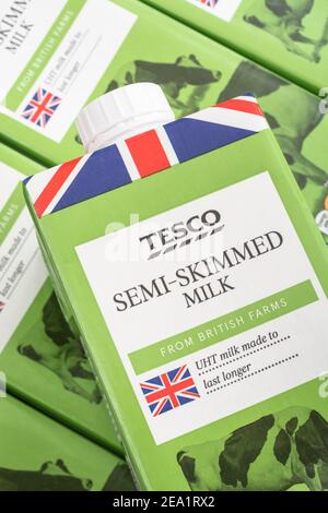 Nahaufnahme von Papierkartons mit Tesco-Eigenmarke langlebiger UHT-Halbmagermilch. Für britische Lebensmittel, Union Jack auf Lebensmittelverpackungen, UK Molkerei. Stockfoto