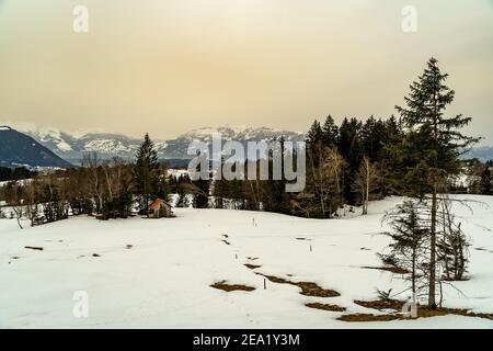 Winter Landschaft mit Sahara Sandwolke, Landschaft mit sandigen Wolken und verschneiten Bergen, Schneefeld und Wäldern. Säntis und Alpstein im Hintergrund Schnee Stockfoto