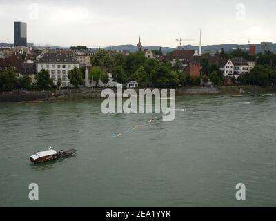 Rheinüberquerung in Basel durch kleine Fähren manuell gegen die Strömung gezogen auf einem Seil über dem Fluss aufgehängt. Stockfoto