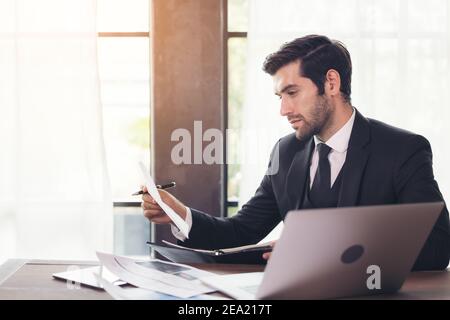 Seitenansicht des jungen Geschäftsmannes, der Computer benutzt, während er sitzt Schreibtisch im Heimbüro Stockfoto