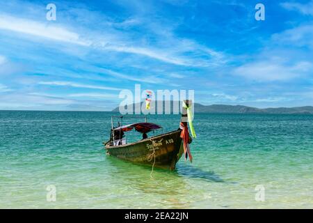 Ein einsames thailändisches Long-Tail-Boot, das am Railay Beach in Krabi, Thailand, festgemacht ist. Long-Tail Boote sind eine traditionelle Form des Transports. Stockfoto