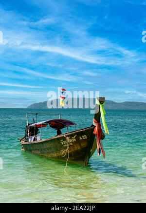 Ein einsames thailändisches Long-Tail-Boot, das am Railay Beach in Krabi, Thailand, festgemacht ist. Long-Tail Boote sind eine traditionelle Form des Transports. Stockfoto