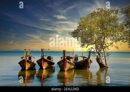 Vier Langschwanz-Boote, die am Railay Beach in Krabi, Thailand, festgemacht sind. Diese Boote sind die traditionelle Form des Wassertransports in Krabi Stockfoto