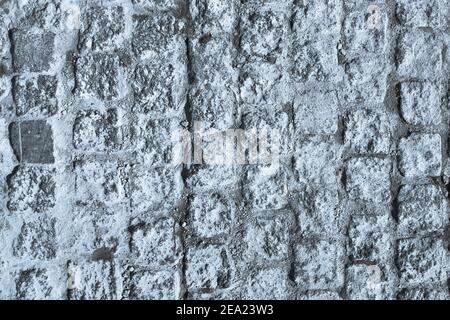 Schwarze und weiße Pflastersteinpflaster Textur. Nahaufnahme von Blöcken. Blau getöntes Bild. Stockfoto