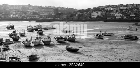 Weitwinkel Blick auf viele Fischerboote und andere auf dem Sand in St. Ives Hafen gelegt. Leer und ruhig wegen der globalen Pandemie-Sperre von Covid-19 Stockfoto