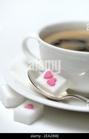 Zuckerwürfel mit Zuckerherz und Tasse Kaffee, Zuckerkonsum, Zuckerkonsum Stockfoto