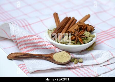 Weihnachtliche Gewürze in Schüssel und Pulver in Löffel, Sticks, Sternanis, Ingwer Stockfoto