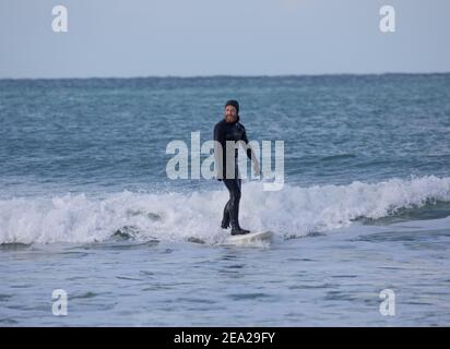 St. Gothian Sands,Cornwall,7th. Februar 2021,an einem kalten aber sonnigen Tag nutzten Surfer die Wellen in St. Gothian Sands,Cornwall. Die Prognose ist, sonnige Intervalle mit einer moderaten Brise für den Rest des Tages zu sein.Quelle: Keith Larby/Alamy Live News Stockfoto