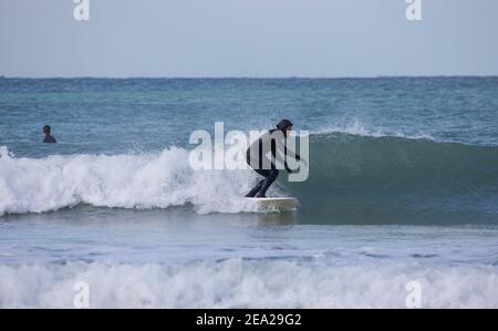 St. Gothian Sands,Cornwall,7th. Februar 2021,an einem kalten aber sonnigen Tag nutzten Surfer die Wellen in St. Gothian Sands,Cornwall. Die Prognose ist, sonnige Intervalle mit einer moderaten Brise für den Rest des Tages zu sein.Quelle: Keith Larby/Alamy Live News Stockfoto