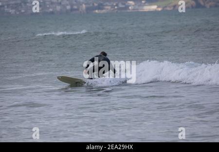 St. Gothian Sands,Cornwall,7th. Februar 2021,an einem kalten aber sonnigen Tag nutzten Surfer die Wellen in St. Gothian Sands,Cornwall. Die Prognose ist, sonnige Intervalle mit einer moderaten Brise für den Rest des Tages zu sein.Quelle: Keith Larby/Alamy Live News Stockfoto