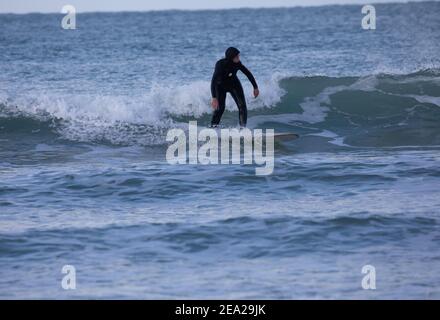 St. Gothian Sands,Cornwall,7th. Februar 2021,an einem kalten aber sonnigen Tag nutzten Surfer die Wellen in St. Gothian Sands,Cornwall. Die Prognose ist, sonnige Intervalle mit einer moderaten Brise für den Rest des Tages zu sein.Quelle: Keith Larby/Alamy Live News Stockfoto