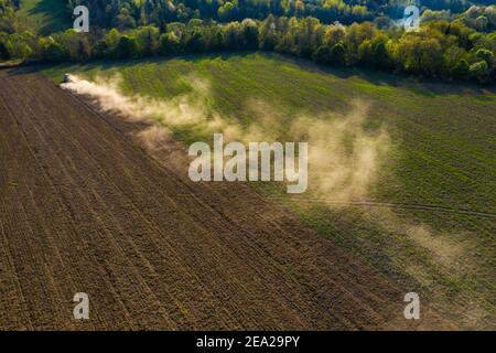 Ukrainische Felder werden von einem Traktor kultiviert, das Feld wird vor der Aussaat Getreide angebaut, Draufsicht, ein Wald kann auf dem horizon,2021 gesehen werden Stockfoto