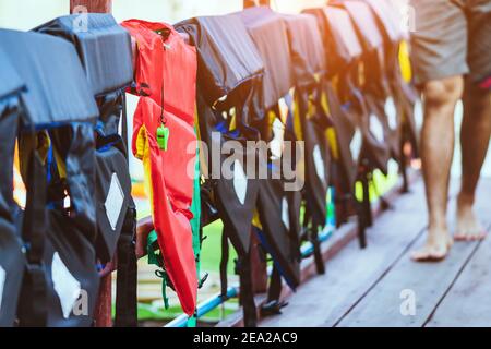 Eine grüne Pfeife mit roter Lebensjacke, die am Geländer um den Gehweg hängt, damit die Passagiere sicher an den Docks sind. Stockfoto