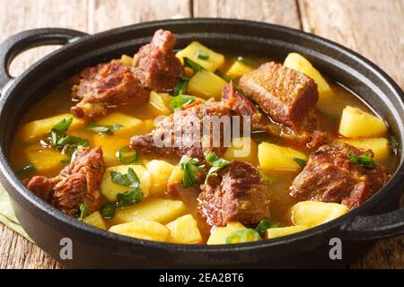 Aloo Gosht ist ein Fleisch Curry beliebt in pakistanischen, bangladeschischen und nordindischen Küche Nahaufnahme in der Pfanne auf dem Tisch. Horizontal Stockfoto