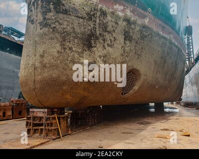 Branchenansicht - Ozeanschiff im Trockendock in der Werft. Altes rostes Schiff wird repariert Stockfoto