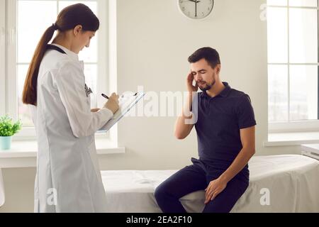 Junge Frau Arzt Krankenschwester in Uniform Notizen während des Besuchs Mit einem Patienten Stockfoto