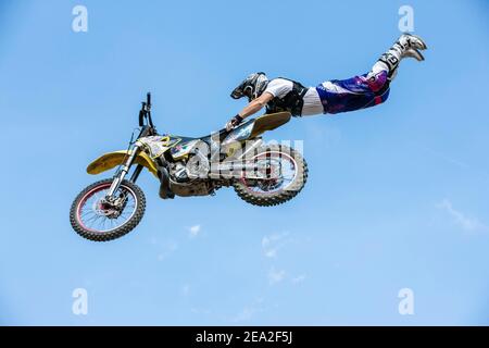 Motocross-Fahrer springt vor blauem Himmel, Biberach, Baden-Württemberg, Deutschland Stockfoto