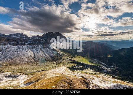 Abendsonne strahlt durch Wolken in eine bunte Herbstlandschaft der Puez-Geisler Berge, Dolomiten, mit Gampenalp, Geisler Alp, Rasciesa Stockfoto