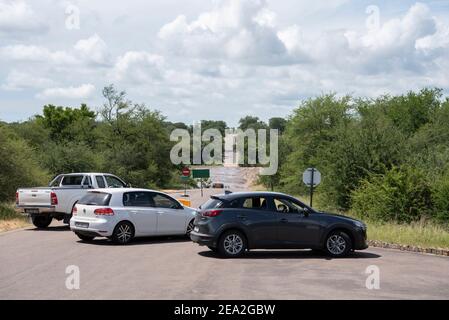 Fahrzeuge, die wegen einer Straße einen Umweg machen müssen Im Kruger Park geschlossen, weil eine Brücke war Unter Wasser Stockfoto