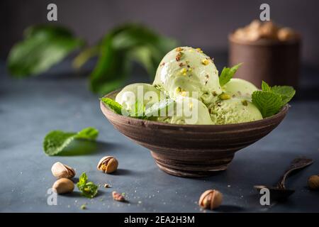 Hausgemachte Pistazien Eislöffel mit gehackten Pistazien auf grauem Stein Hintergrund Stockfoto