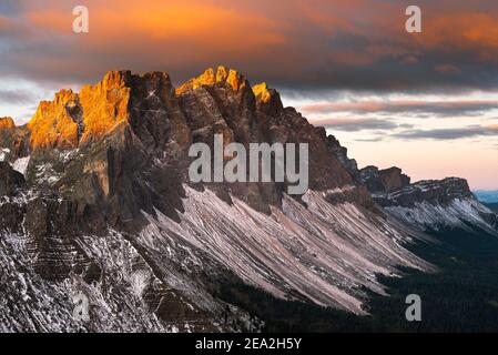 Wolken, Klippen und Gipfel der Geisler glühen bei Sonnenaufgang in den Dolomiten, im Villnößtal, in Südtirol, Italien, golden im Sonnenlicht Stockfoto