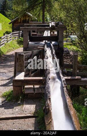 Hölzerne Wasserleitung für das Wasserrad einer historischen Mehlmühle im Mühlental von Campill an, Südtirol, Italien Stockfoto