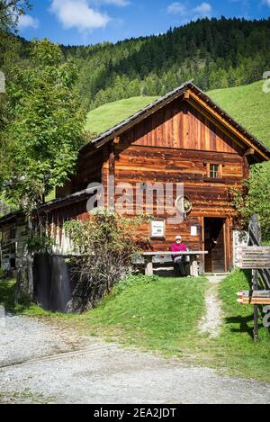 Rustikale Blockhütte einer historischen Getreidemühle mit Wasserrad im Mühlental von Campill, Südtirol, Italien Stockfoto