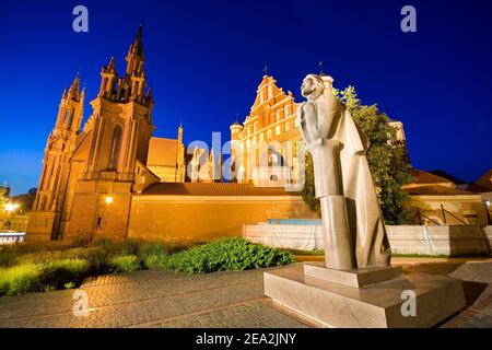 Nachtansicht der beleuchteten Mickiewicz-Statue in der Maironio-Straße in der Altstadt von Vilnius, Litauen. Gotischer Stil St. Anne Kirche und St. Francis und Stockfoto