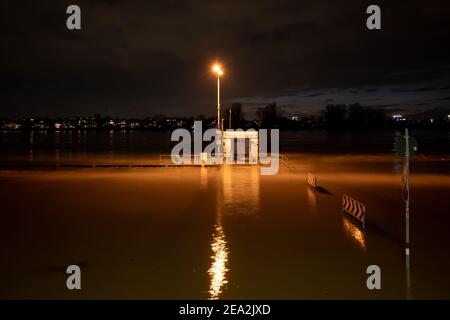 Blick auf die Nacht im Freien auf überschwemmtes Gebiet entlang der Uferpromenade am Rheinufer über Pier und Ponton in Düsseldorf, Deutschland. Stockfoto