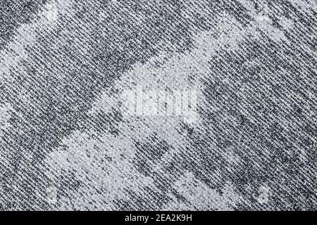 Detail eines grauen zweifarbigen Teppichs mit diagonalen Linien und einem abstrakten Muster. Stockfoto